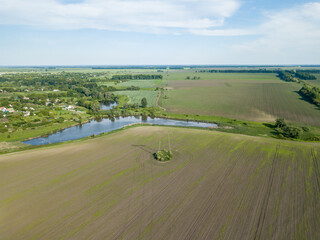 Obraz premium Lake among agricultural fields. Aerial drone view.