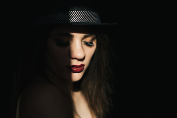 dramatic portrait of sexy young girl in black hat with red lipstick