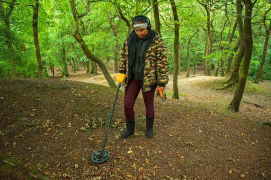 Asian Female Metal Detecting in Woodland Forest
