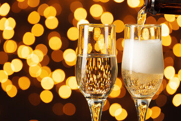 Two glasses of Champagne against bokeh lights background