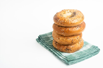 A Stack Of Four Freshly Baked Bagels On A Green Napkin