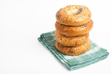 A Stack Of Four Freshly Baked Bagels On A Green Napkin