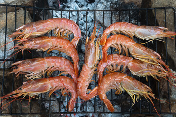 Large Argentine shrimp. Cooking at the stake. Grilled food. Natural conditions. Seafood. Bonfire.