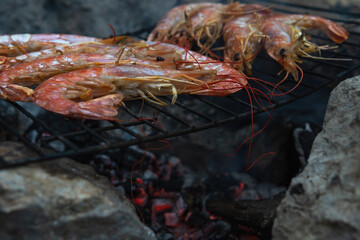 Large Argentine shrimp. Cooking at the stake. Grilled food. Natural conditions. Seafood. Bonfire. Place for text. Copy space