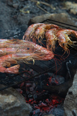 Large Argentine shrimp. Cooking at the stake. Grilled food. Natural conditions. Seafood. Bonfire. Place for text. Copy space. Vertical photo