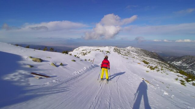 intermediate female skier skiing on slopes on a sunny day.