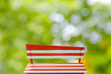 Colorful benches painted red and white with metal legs present a natural background decoration ,...