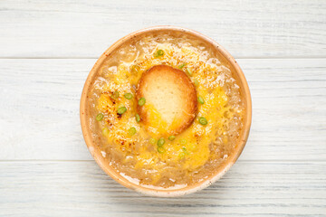Tasty homemade french onion soup on white wooden table, top view