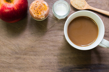 Breakfast soft boiled egg with black coffee and one apple on wooden table. Eating breakfast is important for everyone.