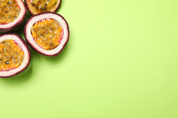 Fresh ripe passion fruits (maracuyas) on light green background, flat lay. Space for text