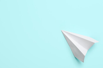 Naklejka premium White paper plane on light blue background, top view. Space for text