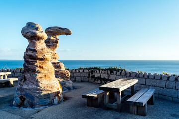 Wooden table and benches with rock formations near by for seaside picnic in Greystones marina in County Wicklow, Ireland