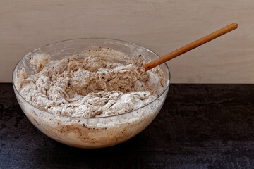 Mixing sourdough dough in glass bowl for further bread baking. Homemade bread preparation.
