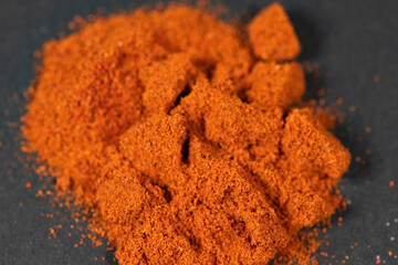 Powdered pimienta roja red pepper pile from top on black background