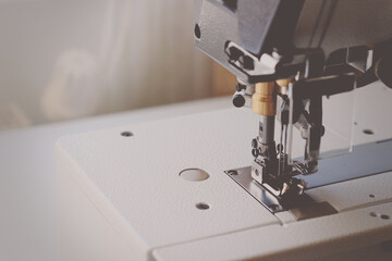 Industrial flat-seam sewing machine. Close-up. Soft focus