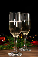 Two Glasses of Champagne against Dark Background. festive decorations, selective focus.