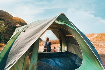 wanderlust and relax in nature with solo hiker man camping on top of mountain on spring and summer season