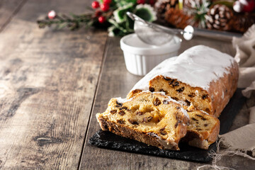 Christmas stollen fruit cake on wooden table.	Copy space