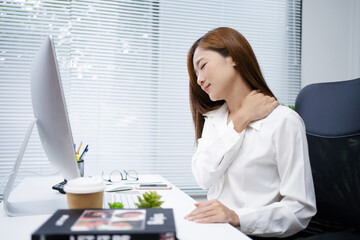 Asian women have shoulder pain caused by hard work in the office.
