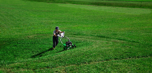 Lawn Mower. The worker cuts the lawn.