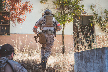 Fototapeta premium Soldier in a combat situation. Men play airsoft.