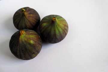 three green figs on a gray background side view