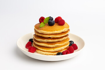 Delicious pancakes with raspberry and blueberry on White background