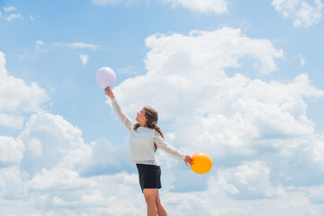 Fly with helium balloons. Higher and higher everyday. Cheerful girl have fun. Summer holidays and...