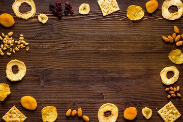 Snacks mix frame top view. Nuts and dried fruits with crackers, copy space