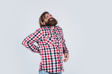 guy with pain in back. problems with health. suffering man has backache. unhappy bearded man in checkered shirt. male health concept. Portrait of bearded hipster