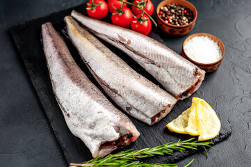
raw fish hake with spices on a stone background