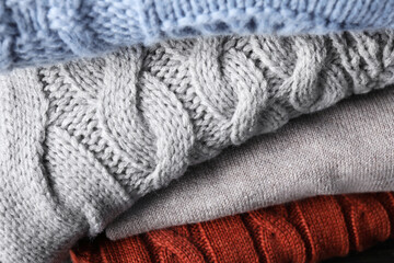 Stack of folded warm sweaters, closeup view