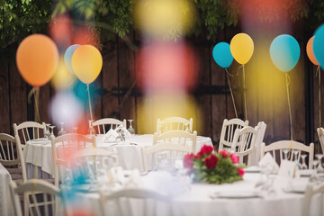 Holiday party decoration. The Colorful balloons attached to the table. Decorated balloons for...