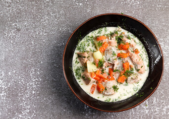 Lohikeitto, finnish traditional salmon soup in a bowl on a dark background. Top view, flat lay