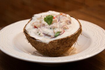 Ceviche served inside fresh coconut. Seafood ceviche, typical dish from Peru