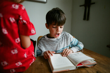 boy reads book aloud