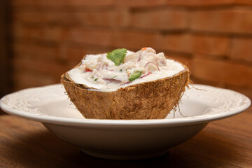 Ceviche served inside fresh coconut. Seafood ceviche, typical dish from Peru