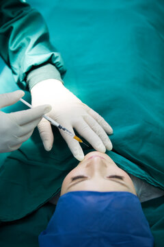 Patient on operating table receiving plastic surgery