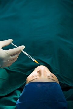 Patient on operating table receiving plastic surgery