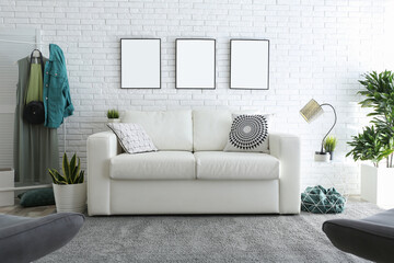 Stylish room interior with empty posters on white brick wall. Mockup for design