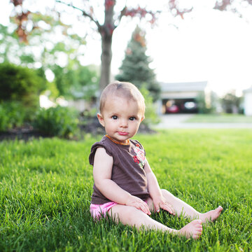 baby girl sitting tall in grass