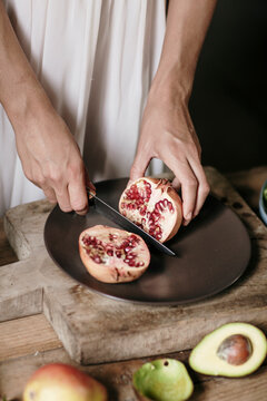 Cook slitting fruit on shabby cutting board