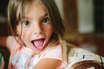 girl makes silly faces on couch