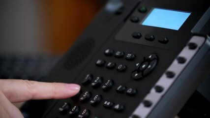 Office worker uses a landline phone to answer incoming calls and dialing a number to make a call. Businesswoman picking up the phone to answer a phone call. Close-up of women's hands with a phone