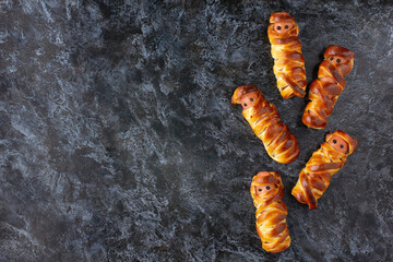 Scary sausage mummies in dough for kids party. Funny crazy Halloween food for children.