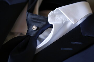 dettaglio di un gioiello nella cravatta di uno sposo