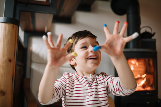 Young boy showing his hands with tempera and smiling