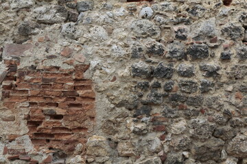 texture di un muro di cemento con mattoni rossi e sassi colorati