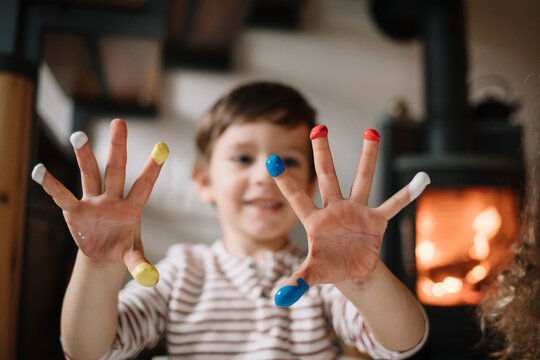 Young boy showing his hands with tempera and smiling