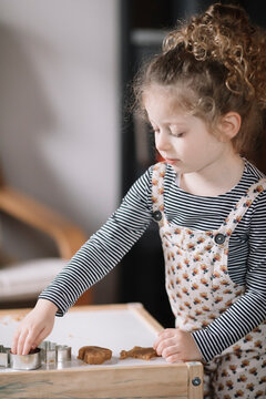 Cute little girl making cookies while having fun